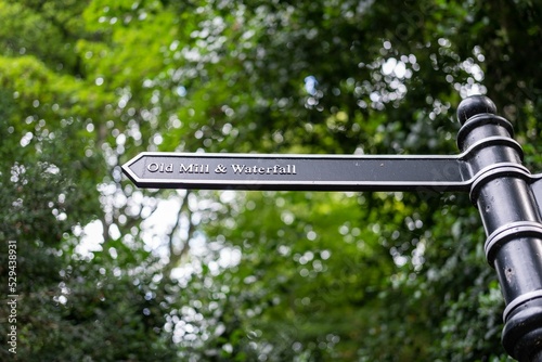 A signposts directs visitors to the old mill and waterfall in Jesmond Dene, Newcastle upon Tyne, UK