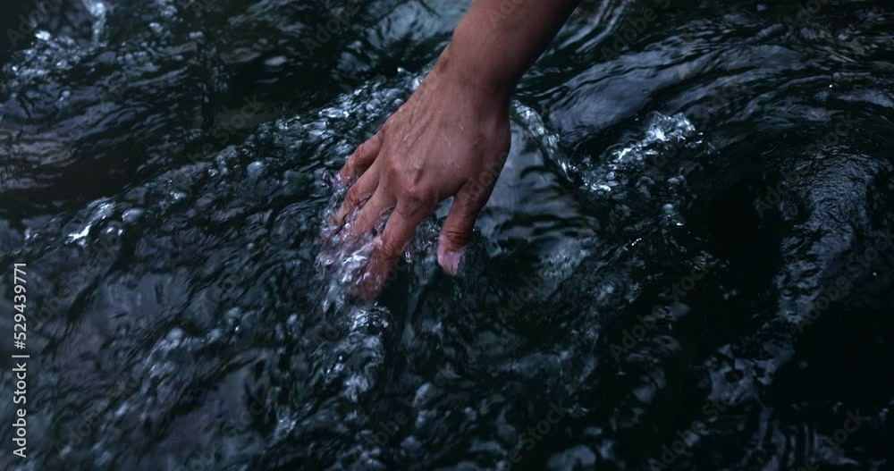 Stream water flowing on hand.