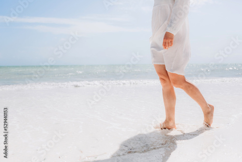 Woman feet walking on caribbean beach barefoot closeup of foot coming out of water after swim banner panorama. Honeymoon travel vacation