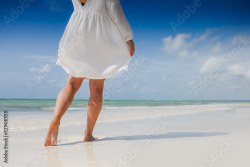 Woman feet walking on caribbean beach barefoot closeup of foot coming out of water after swim banner panorama. Honeymoon travel vacation