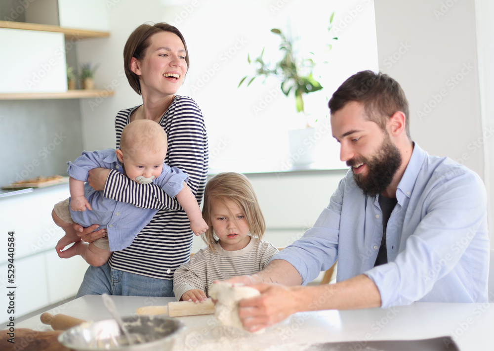 Young parents playing with children in the kitchen Young parents playing with children in the kitchen