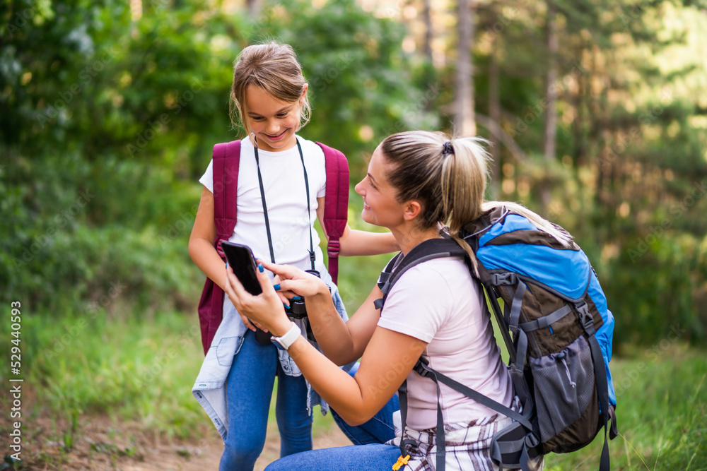 Mother and daughter using map on mobile phone and enjoy hiking together. Mother and daughter using map on mobile phone and enjoy hiking together.
