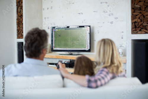 Happy caucasian family watching football match together and sitting on the couch