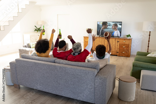 Happy african american family watching football match together and sitting on the couch