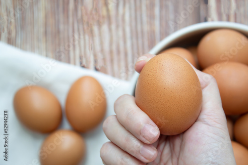 Woman's hand pick up egg bowl and holding it to preparing food.