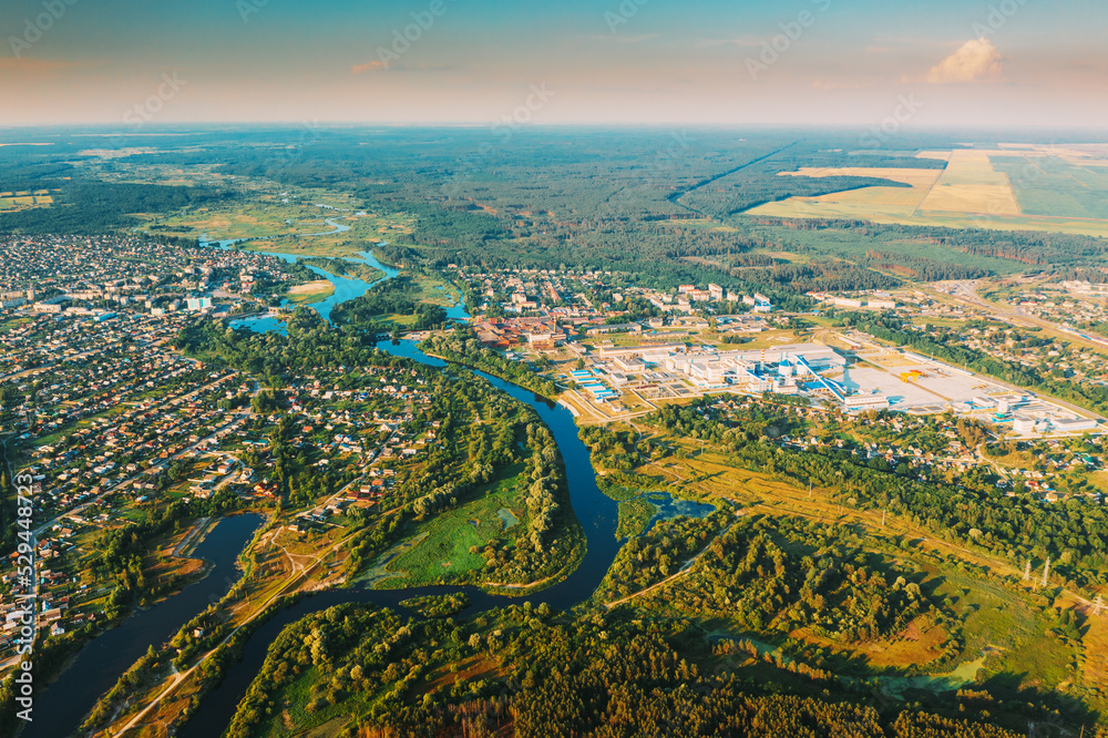 Aerial View Of Town Village Cityscape Skyline In Summer Sunny Morning. Daytime. Residential Houses, River Divides Small European City. Residential Areas And Industrial Area.