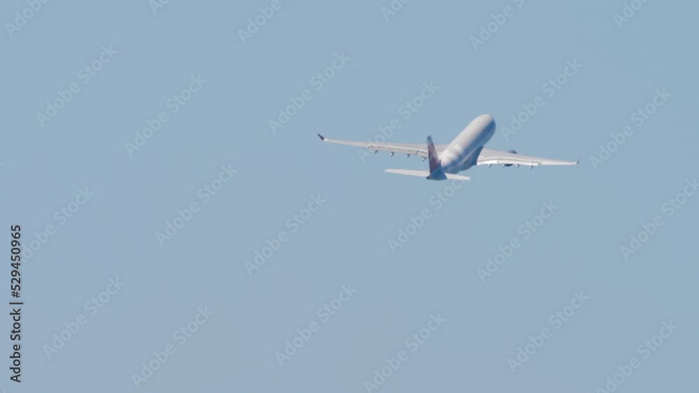 Wide body airliner departure, rear view. Long shot of a passenger plane flying away Wide body airliner departure, rear view. Long shot of a passenger plane flying away