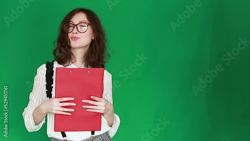 Female in glasses, formal attire. Woman in office suit with documents in her hands on a Green Screen. Chroma Key.