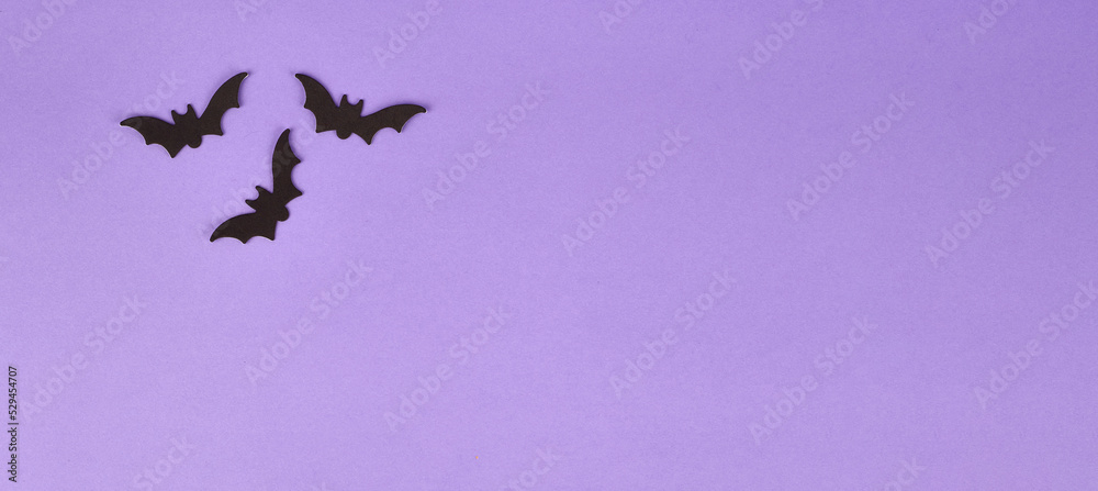 Fototapeta premium Halloween decorations, pumpkins, on violet background. Halloween party greeting card. Copy space. Flat lay, top view, overhead.