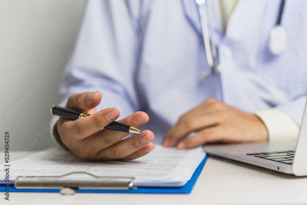 Doctor hand holding pen write and paperwork document patient treatment on clipboard.Business health care concept.