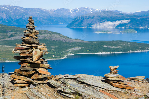 Pile of stones with beautiful view of Kvaenangen fjord and Skorpa island in the background, Norway photo