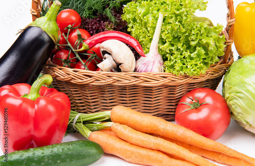 Variety of fresh organic vegetables and leafy greens in basket close view