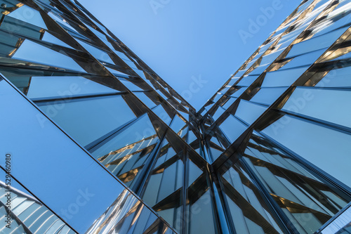 The blue sky is reflected in the windows of the modern glass facade. architectural abstraction. Modern space.