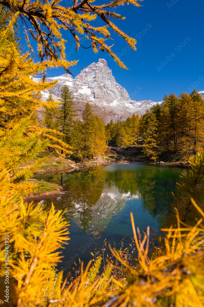 view of the Matterhorn mountain reflected in the blue lake in autumn, Cervinia, Valle d'Aosta, Italy