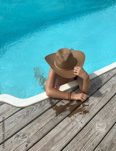 Woman in sunhat relaxing in the pool