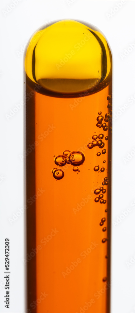Yellow viscous liquid sunflower lecithin with bubbles in a transparent test tube on a white background Yellow viscous liquid sunflower lecithin with bubbles in a transparent test tube on a white background