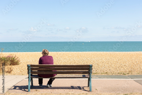  Woman Relaxing On A Park Bench On A Clear Summers Day, looking out towards the sea © © Raymond Orton