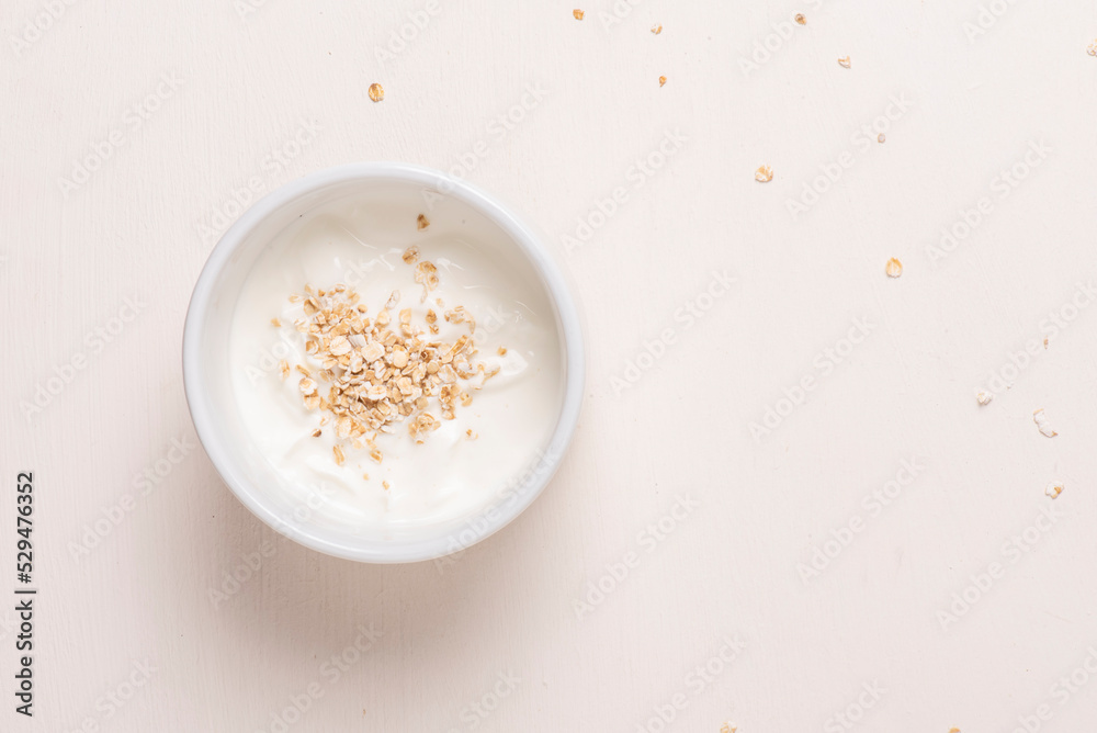 Bol blanco con yogurt y avena sobre fondo blanco, fotografía minimalista y clara. Desayuno saludable Bol blanco con yogurt y avena sobre fondo blanco, fotografía minimalista y clara. Desayuno saludable