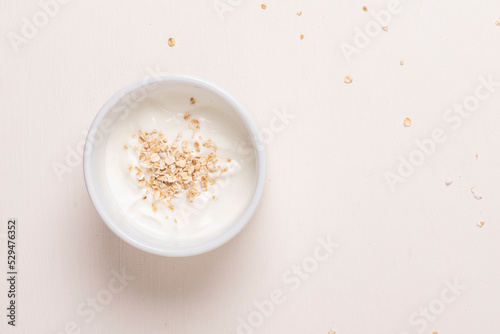Bol blanco con yogurt y avena sobre fondo blanco, fotografía minimalista y clara. Desayuno saludable photo
