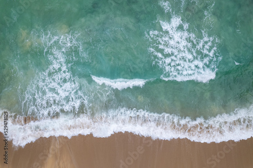 Fototapeta Naklejka Na Ścianę i Meble -  Aerial view waves crashing on sand of beach and soft wave background,Top view