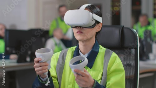 Young woman engineer test vr goggles and controllers in modern industrial laboratory