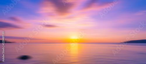 Blurred sea background at sunset, Abstract natural background and texture motion blur,panoramic view of sunrise over ocean.Dark sky sunlight and deep dark water sea background