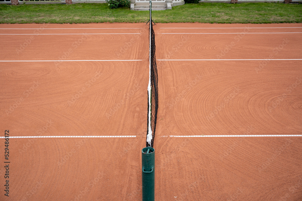a net dividing the clay tennis court