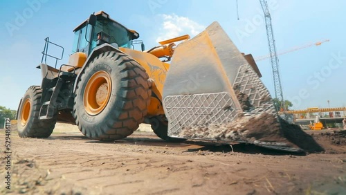 Yellow tractor on a construction site. Professional construction equipment. Work process at a construction site