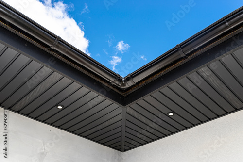 A modern graphite herringbone roof lining is attached to the trusses, visible turned on LED lights.