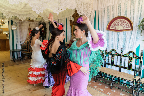 Hispanic women in flamenco dresses dancing in tent