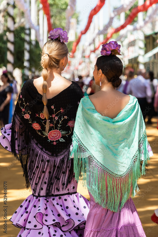 Women in flamenco dresses walking in city