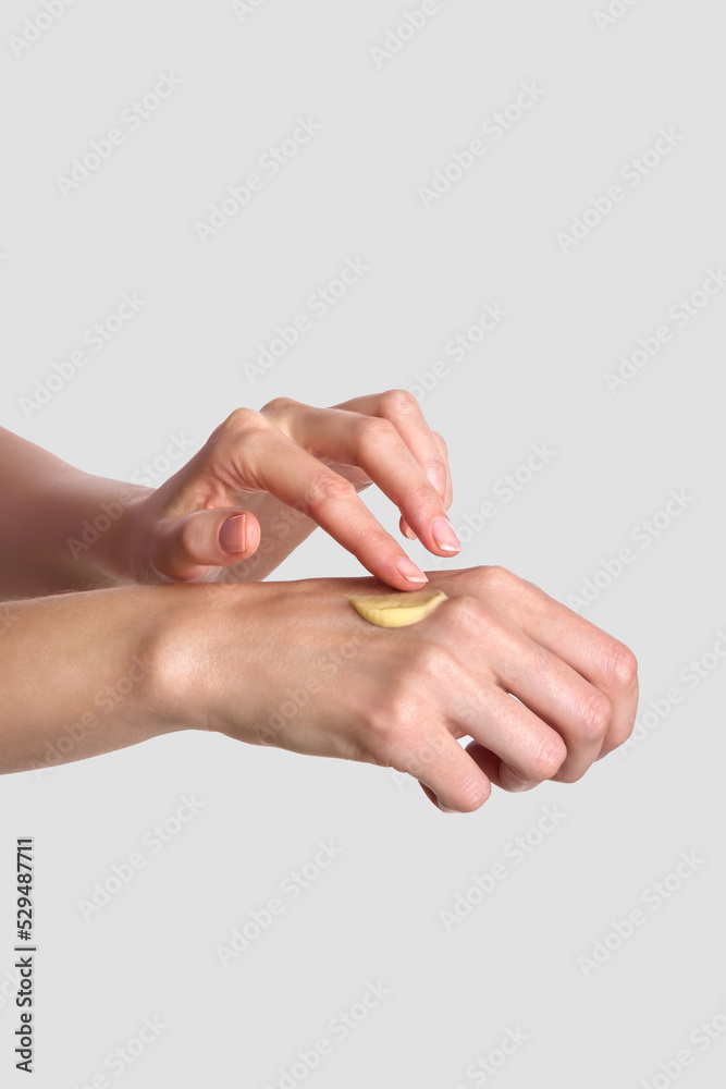 Woman applying lotion to hand. Daily skincare and body care routine. Close up.