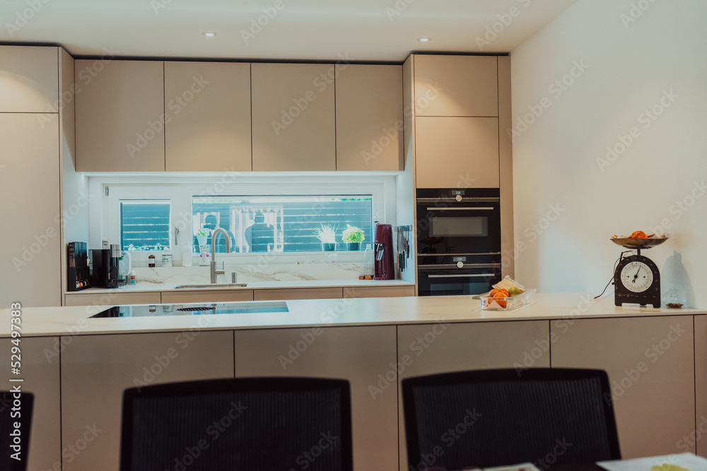 Fototapeta premium Modern white kitchen with electronic devices and decorative items