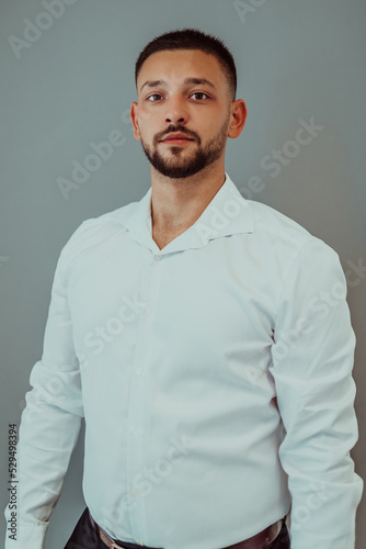 Portrait of a business man with crossed arms on a gray background