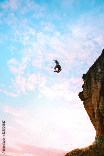 Man jumping off cliff into ocean
