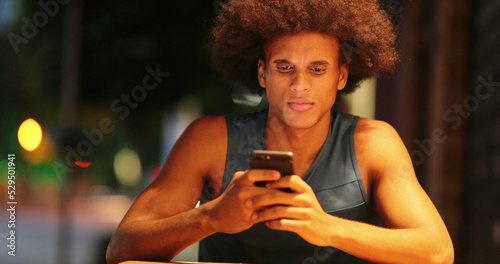 African man holding cellphone in disbelief nodding negative to news
