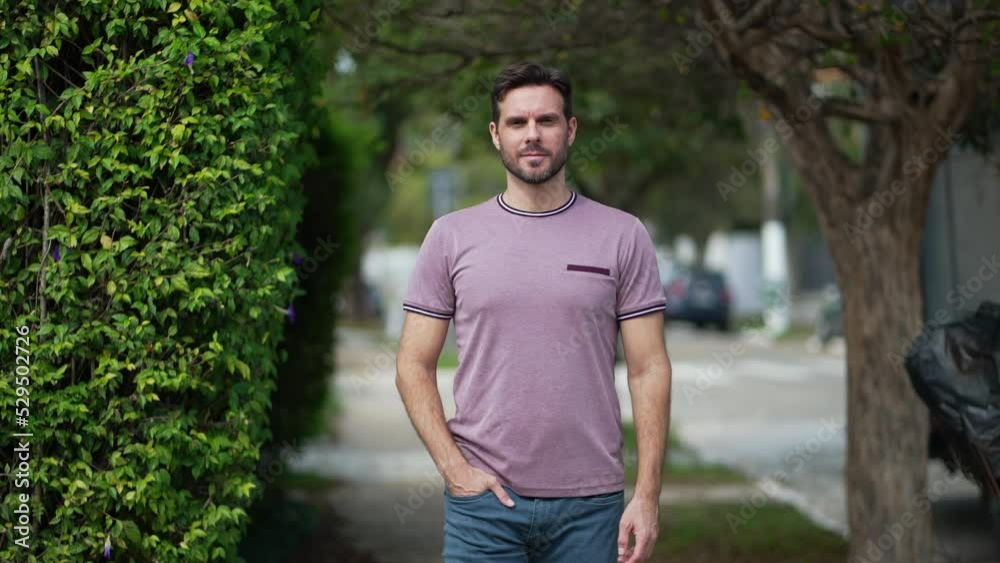 Young handsome man in 30s standing in city street looking at camera. Male person in urban sidewalk Young handsome man in 30s standing in city street looking at camera. Male person in urban sidewalk