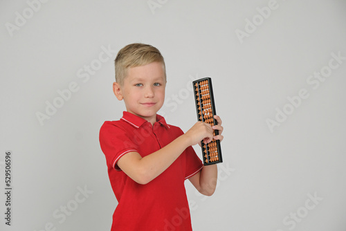Little boy doing simple math exercises with abacus scores. Math and mental arithmeric.
