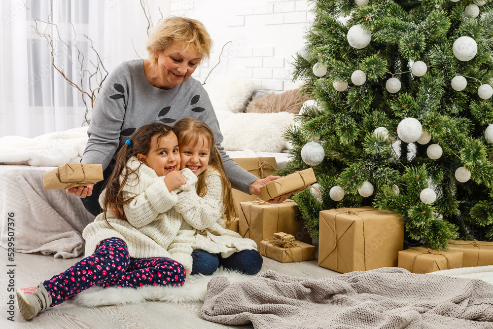 Merry Christmas and Happy Holidays. Grandma and children. The morning Xmas. Portrait loving family Merry Christmas and Happy Holidays. Grandma and children. The morning Xmas. Portrait loving family