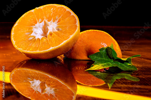 Fototapeta Naklejka Na Ścianę i Meble -  orange on a black background. orange halved. orange in bar. orange cocktail. orange cocktail. tropical fruit. sweet fruit. yellow orange.