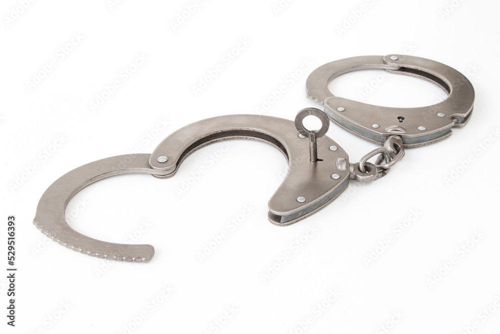 the inserted key opens the handcuffs, on a white isolated background the inserted key opens the handcuffs, on a white isolated background