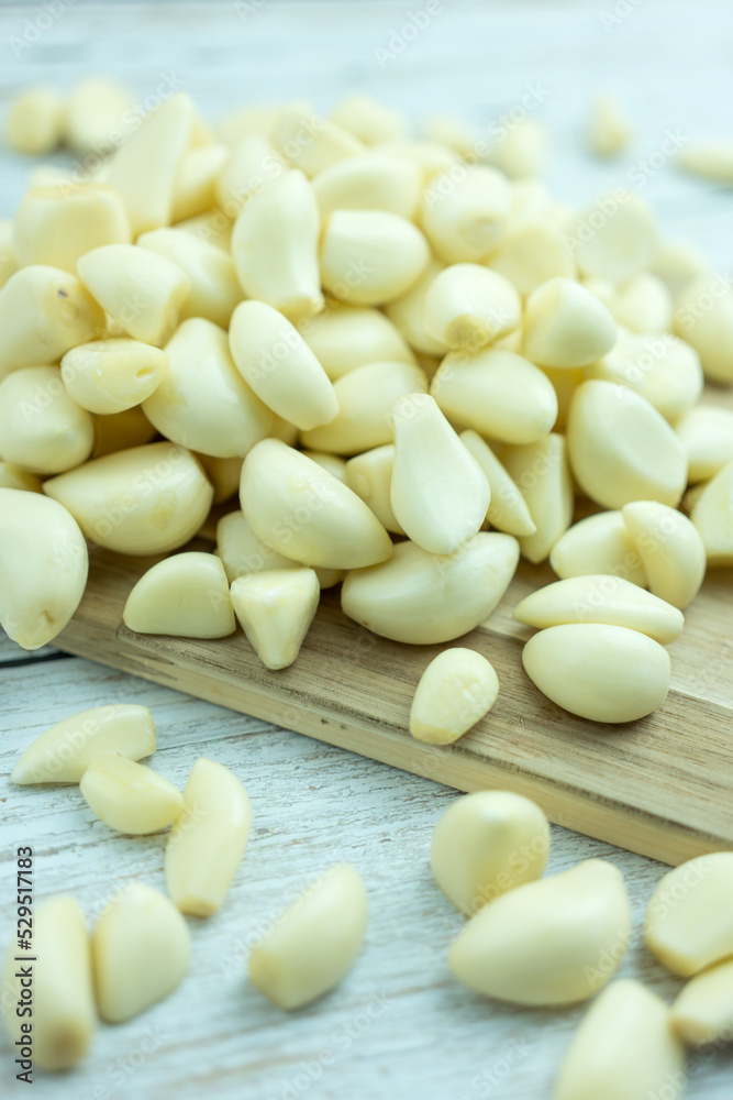 Organic garlic on a wooden cutting board pungent flavor, used as seasoning or condiment and in medicine.