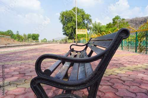 Blank railway sign board, seating bench at railway station platform of mountain village Kalakund near Mhow, Indore, Madhya Pradesh on a sunny summer day. Indian village.
