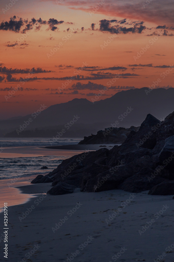 Silhouette of the mountains in a sunset on the sea. Black and reddish colors. Nature