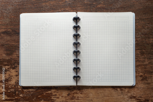 Open checkered notebook on a vintage wooden table top view