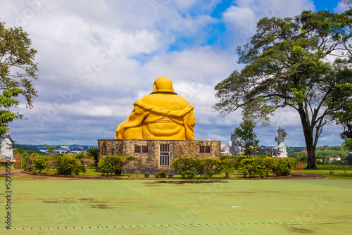 Partial view of Thai temple garden behind Buddha statue