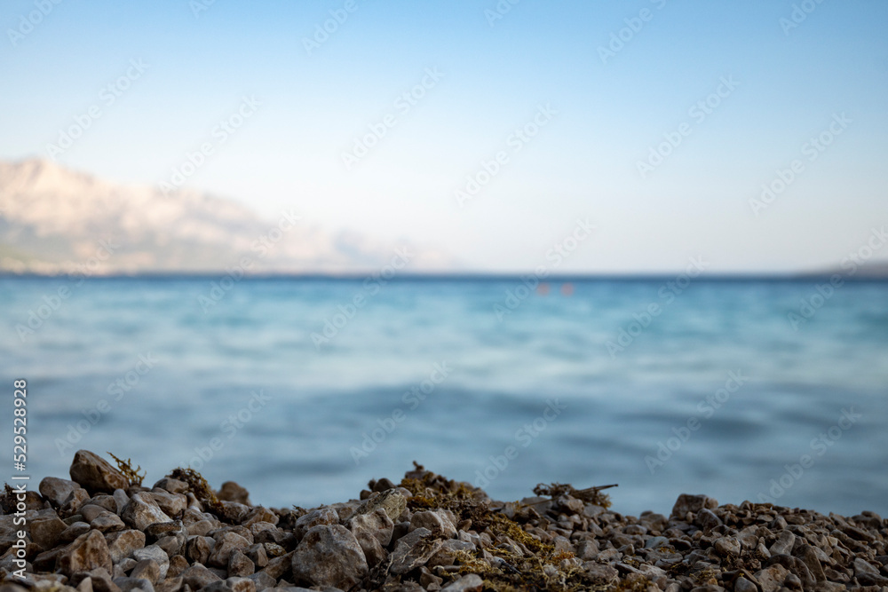 Long exposure of sea and gravel beach edge above the water at Mimice village, Croatia