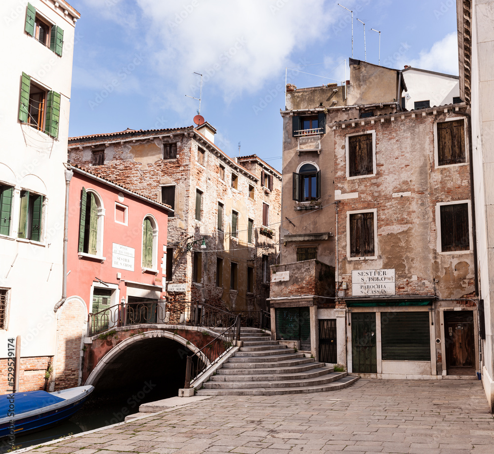 Typical bridge made with red bricks on the typical canal in Venice Typical bridge made with red bricks on the typical canal in Venice