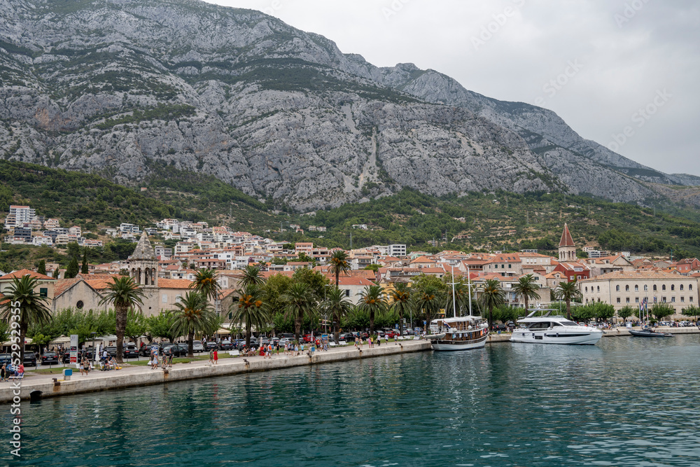 Popular tourist town of Makarska, Croatia under rocky cliffs of Biokovo mountain on Adriatic coast