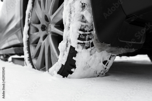 Close-up photo of snowy car wheel on snow tire